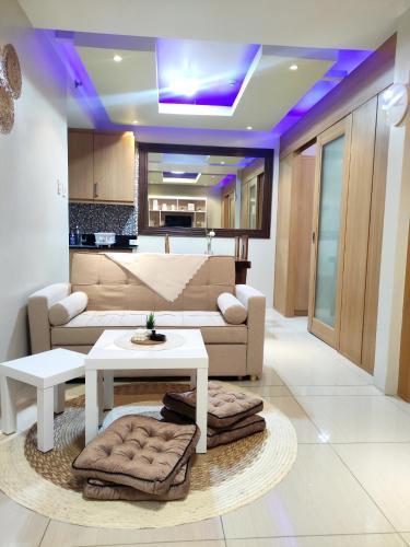 a living room with a couch and a table at Shell res nr MOA 2BR free parking in Manila