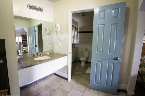 a bathroom with a sink and a toilet and a blue door at Hollywood La Brea Inn in Los Angeles
