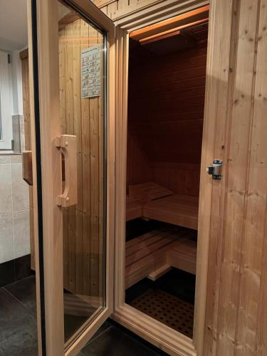 a wooden sauna with a glass door in a room at 205 qm "Traumtor" mit Sauna, Whirlpool, Kamin und 3 Terrassen mit Blick in die Böhmisch Sächsische Schweiz in Dresden