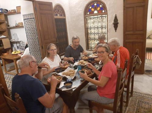 a group of people sitting around a table eating food at Riad Inspira in Meknès
