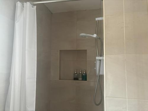 La salle de bains est pourvue d'une douche avec rideau de douche. dans l'établissement 1970s Carratraw Chalet, à Rivory