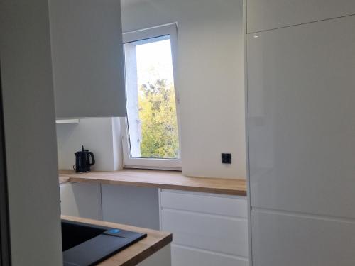 a kitchen with a window and a counter top at Lato Nad Morzem II Gdańsk Brzeźno in Gdańsk