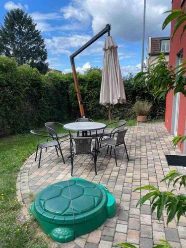 a patio with a table and an umbrella and chairs at Urban house for families and Berlin tourists in Teltow