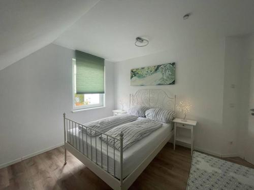 a white bedroom with a bed and a window at Urban house for families and Berlin tourists in Teltow