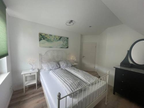 a white bedroom with a bed and a mirror at Urban house for families and Berlin tourists in Teltow