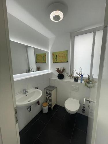 a white bathroom with a sink and a toilet at Urban house for families and Berlin tourists in Teltow