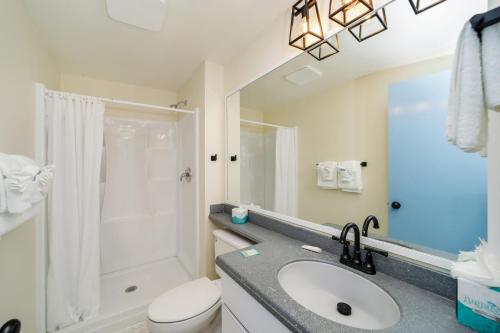 uma casa de banho com um lavatório, um chuveiro e um WC. em Tranquillity Guest House em Key West