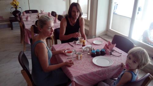 two women and a child sitting at a table at Hotel Meghniwas in Jaipur