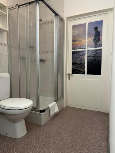 La salle de bains est pourvue d'une douche, de toilettes et d'une fenêtre. dans l'établissement tas24ch Travel and Sleep 24, à Saint-Gall