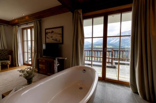 a large bathroom with a tub and a balcony at Chalet Bergmueller in Schladming