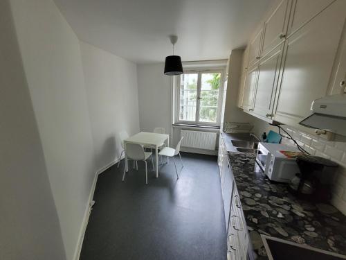 a kitchen with a table and a table and a window at Home Inn KG49 in Stockholm