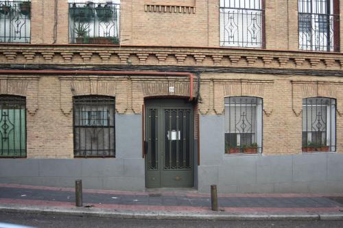 マドリードにあるEstudio Nueva Numanciaの緑の扉のあるレンガ造りの建物