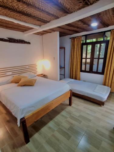 a bedroom with two beds and a large window at Kankui Lodge in El Zaino