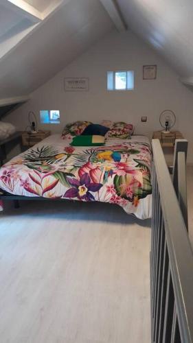 une chambre avec un grand lit dans un grenier dans l'établissement Charmante maisonnette au cœur de la campagne, à Pourrain