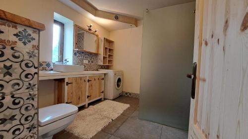 La salle de bains est pourvue de toilettes blanches et d'un lavabo. dans l'établissement Ostoja Leśna Cisza, 