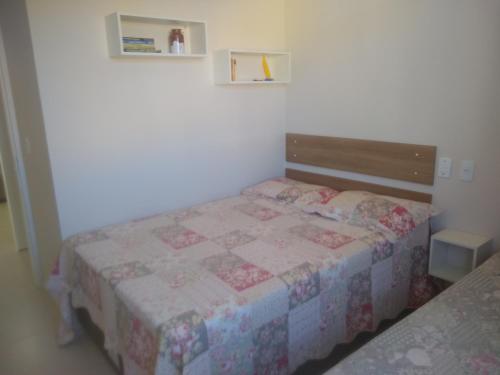Dormitorio pequeño con cama con edredón en Apto Cond.Ilha de Majorca, en Bombinhas