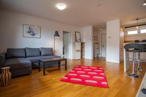 Apartment Central Fulpmes + free parking spot في فولبميس: غرفة معيشة مع أريكة وسجادة حمراء
