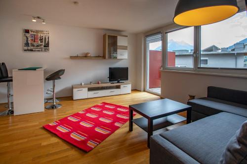 a living room with a couch and a red rug at Apartment Central Fulpmes + free parking spot in Fulpmes