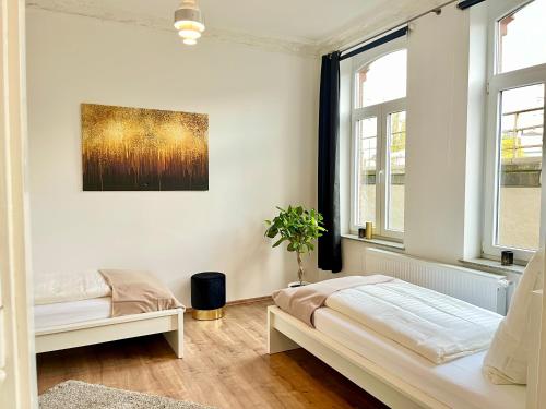 biała sypialnia z łóżkiem i 2 oknami w obiekcie Golden Deer Apartment - 3 Schlafzimmer - Zentrum - 92m² w Hanowerze