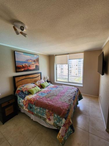 a bedroom with a bed and a large window at Departamento Laguna Vista Oceano in Algarrobo