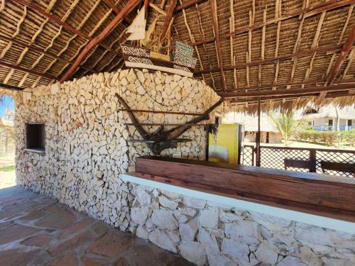 a building with a stone wall with a bench on it at Karibuni, Villa 107, Beachfront Stay with Restaurant, Pool & Bar in Malindi