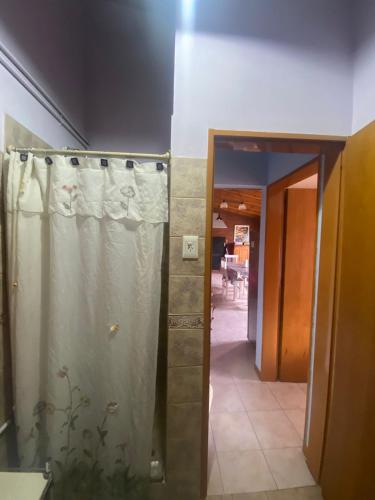 a bathroom with a shower curtain and a doorway at Departamento Trelew in Trelew