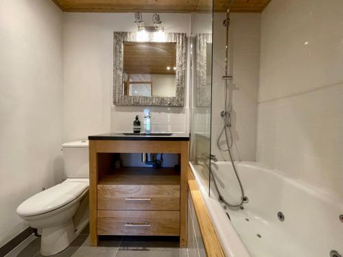 ein Badezimmer mit einem Waschbecken, einer Badewanne und einem WC in der Unterkunft Ski in-Ski out! Spacious & Stylish Apartment for 8 in the heart of Lavachet in Tignes
