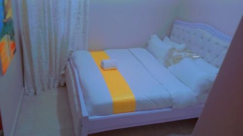 a small bed with a yellow and blue blanket on it at Kathy's Place in Runda in Nairobi