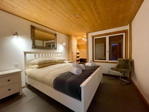- une chambre avec un lit, une chaise et une fenêtre dans l'établissement Ski in-Ski out! Spacious & Stylish Apartment for 8 in the heart of Lavachet, à Tignes