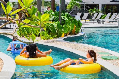 two girls riding on inflatables in a swimming pool at Salinas Premium Resort A&D in Salinópolis