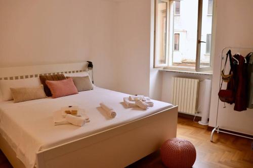 ein Schlafzimmer mit einem weißen Bett und Handtüchern darauf in der Unterkunft Cozy Flat in Piemonte in Acqui Terme