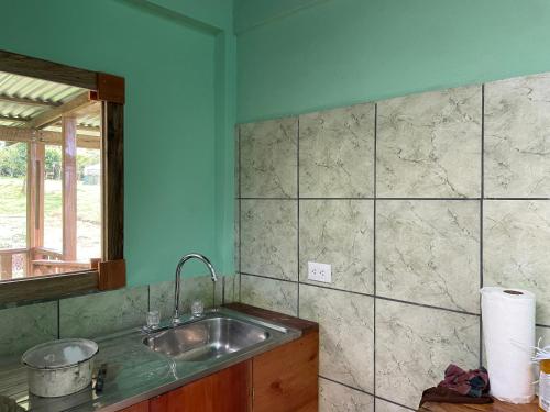 eine Küche mit einem Waschbecken und einem Spiegel in der Unterkunft Granja Integral Luz Del Corazon 