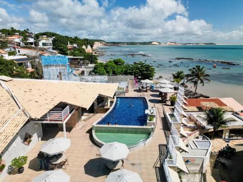 a resort with a swimming pool next to the ocean at Sonia Flats Pipa's Bay - Flat 211 in Pipa