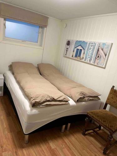 Cama en habitación con ventana y silla en Gimle Casa en Tromsø