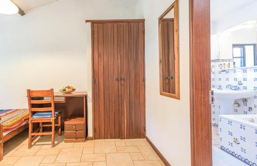 a bathroom with a wooden door and a desk at Quinta de São Pedro in Sobreda