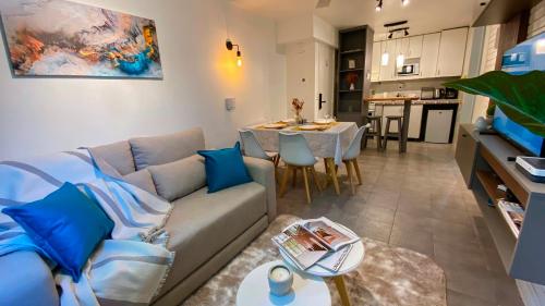 uma sala de estar com um sofá, uma mesa e uma cozinha em Departamento con cochera mejor zona de Mendoza em Mendoza