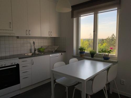 a kitchen with a table and chairs and a window at Home Inn SLV4 in Stockholm