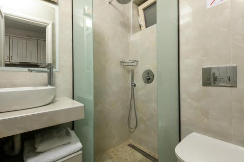 ein Bad mit einer Dusche und einem Waschbecken in der Unterkunft Villa Niti in Chrisi Ammoudia