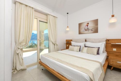 a bedroom with a bed and a large window at Villa Niti in Chrysi Ammoudia