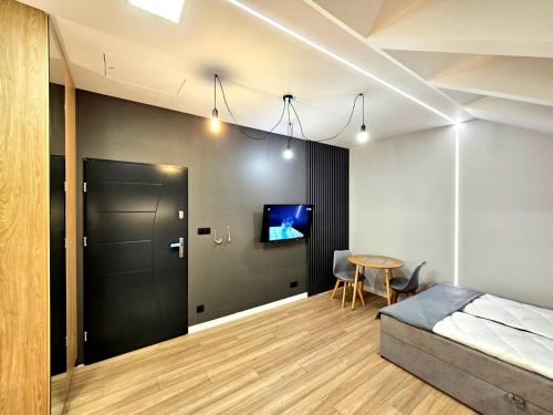 1 dormitorio con cama, mesa y TV en Apartamenty na 102, en Iława