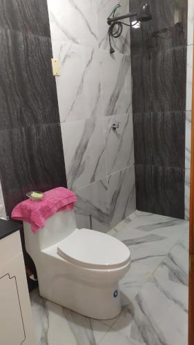 baño con aseo blanco y toalla rosa en Un Lugar para soñar en La Maná