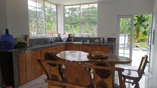 cocina con mesa y algunas ventanas, mesa y sillas en Un Lugar para soñar en La Maná
