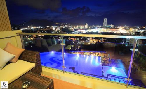 a balcony with a view of a city at night at The Senses Resort & Pool Villas, PHUKET in Patong Beach