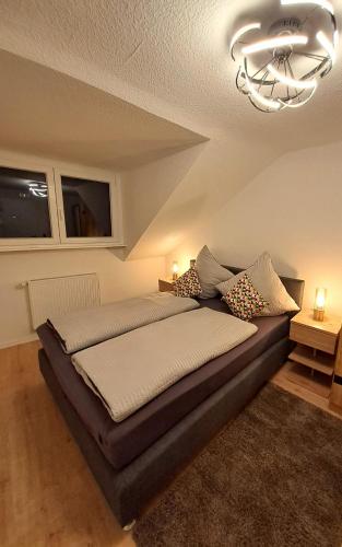 ein Schlafzimmer mit einem großen Bett mit einem Kronleuchter in der Unterkunft Ferienwohnung Rheinsteig in Boppard