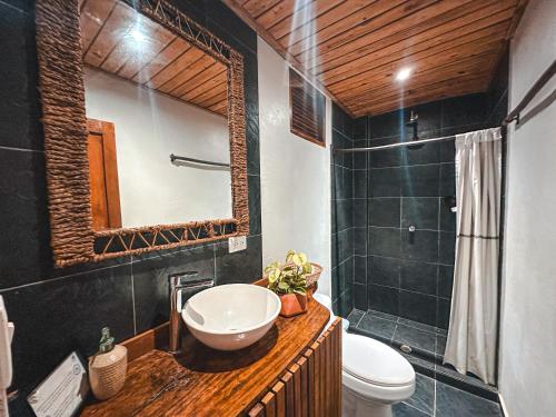 a bathroom with a sink and a toilet and a mirror at Villa Eden Palomino in Palomino