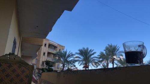 a glass of wine sitting on a balcony with palm trees at شقة بدمياط الجديدة مناطق هادئة in Dumyāţ al Jadīdah