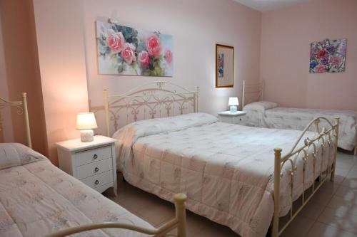 um quarto com duas camas e duas mesas e dois candeeiros em Residenza Relax dei Trulli em Alberobello