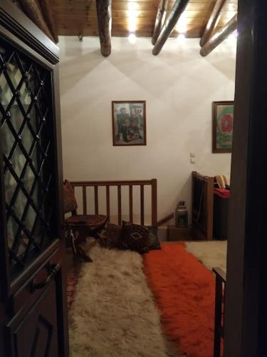 a room with a bedroom with a bed and a red rug at Παραδοσιακή πέτρινη κατοικία στην Βλάχα Ελάτης in Vlácha