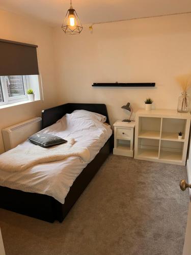 um quarto com uma cama e uma mesa de cabeceira com um candeeiro em Beautiful Countryside Cottage - Old Post Office em Cobham