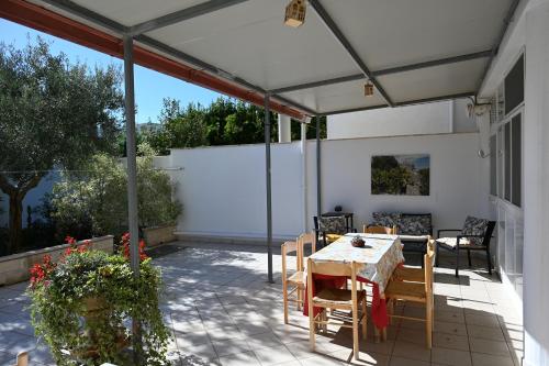 un patio con tavolo e sedie sotto una tenda. di Residenza Relax dei Trulli ad Alberobello